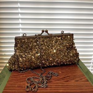 Silver sequined clutch purse with hideaway chain shoulder strap.